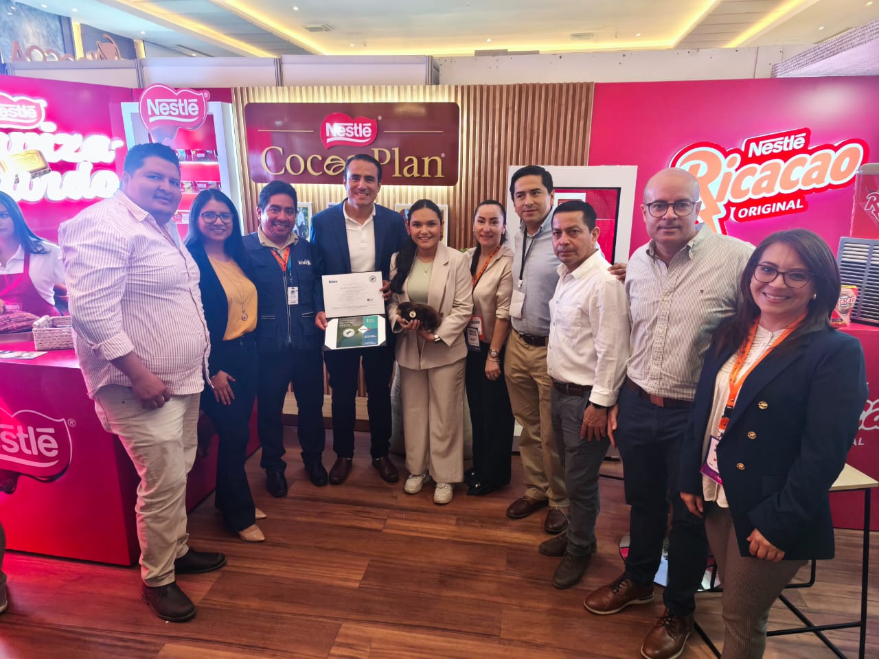Group of people posing at a Nestlé event, showcasing the Cocoa Plan and Ricacao products