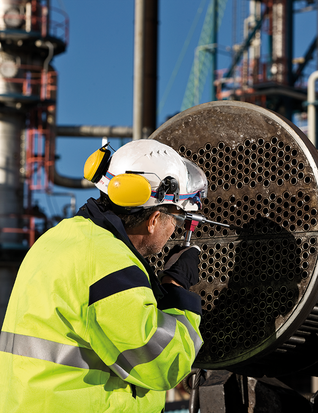 Kiwas besiktningsingenjör utför en kontroll av ett objekt på en industri. 