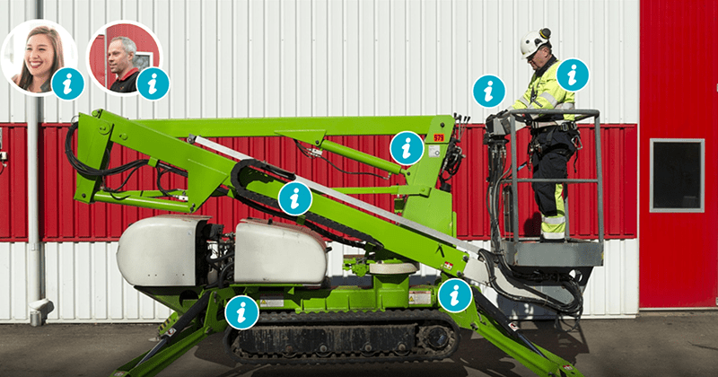 Grön skylift vid en röd byggnad, med en arbetare i arbetskläder och hjälm stående i korgen.