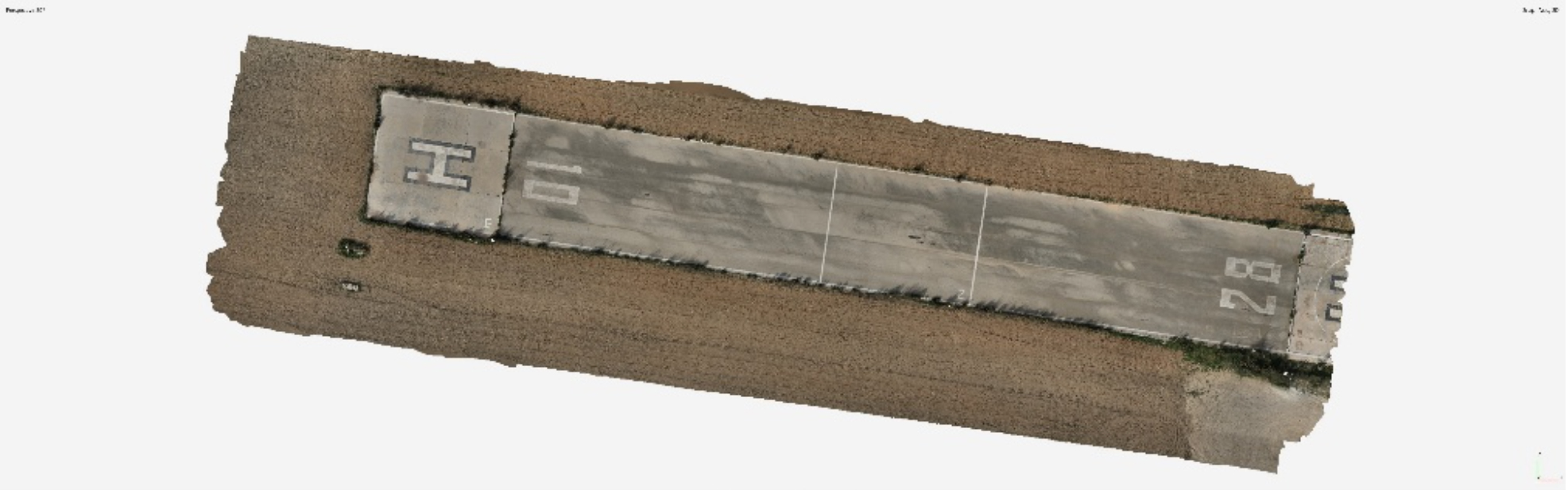 Aerial view of an abandoned concrete runway in a rural area, surrounded by dirt and grass