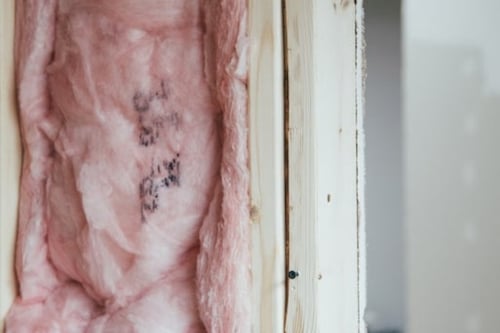 Pink thermal isolation material filling up the middle of a wodden column