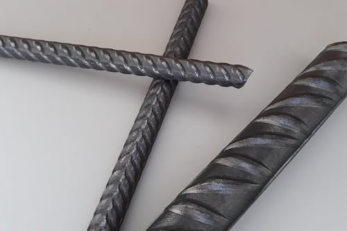 Drie metalen staven met spiraalvormige ribbels op een witte achtergrond.