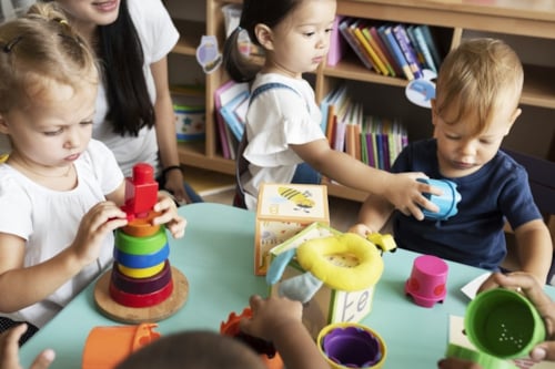 Kinderen spelen met educatief speelgoed aan een tafel in een klaslokaal