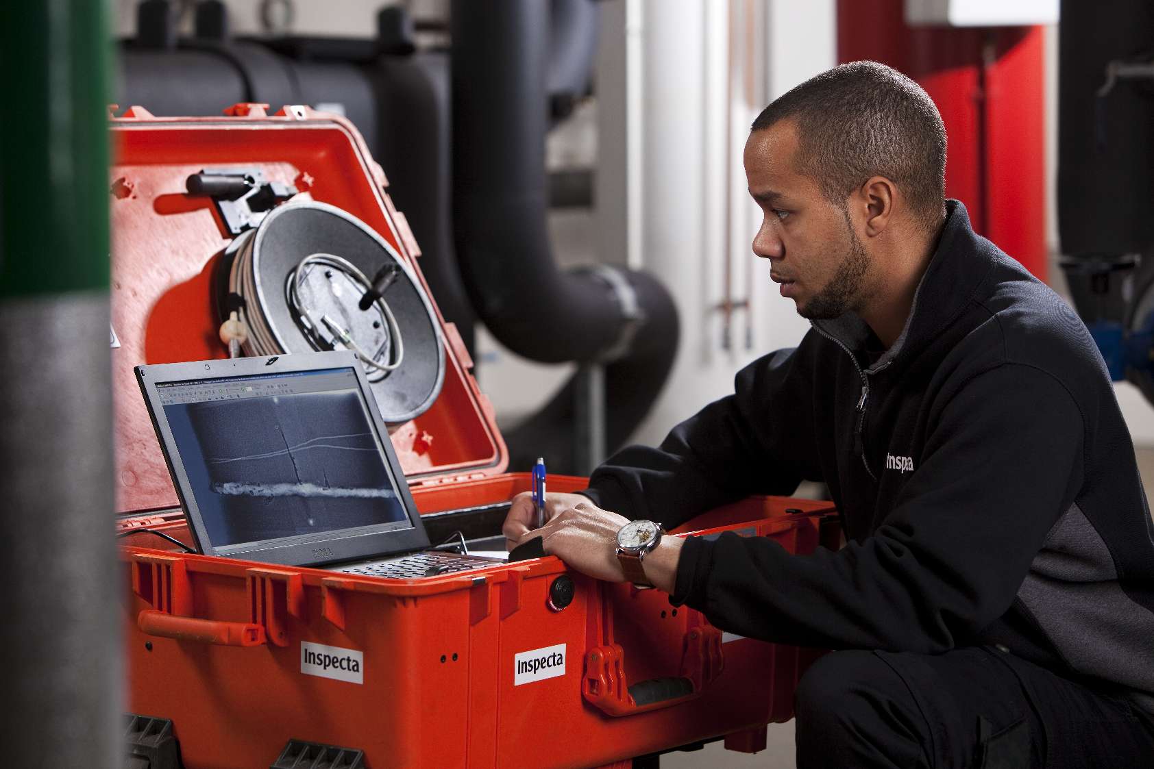 En tekniker med en laptop kontrollerar anordningens säkerhet.