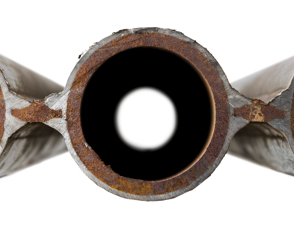Tvärsnitt av ett rör med synlig rost och ett cirkulärt hål i mitten.