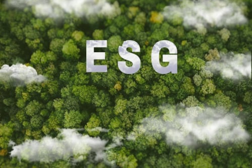 ESG letters over a lush green forest with clouds