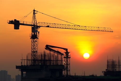 Päikeseloojangul tornkraana tõstmas asju