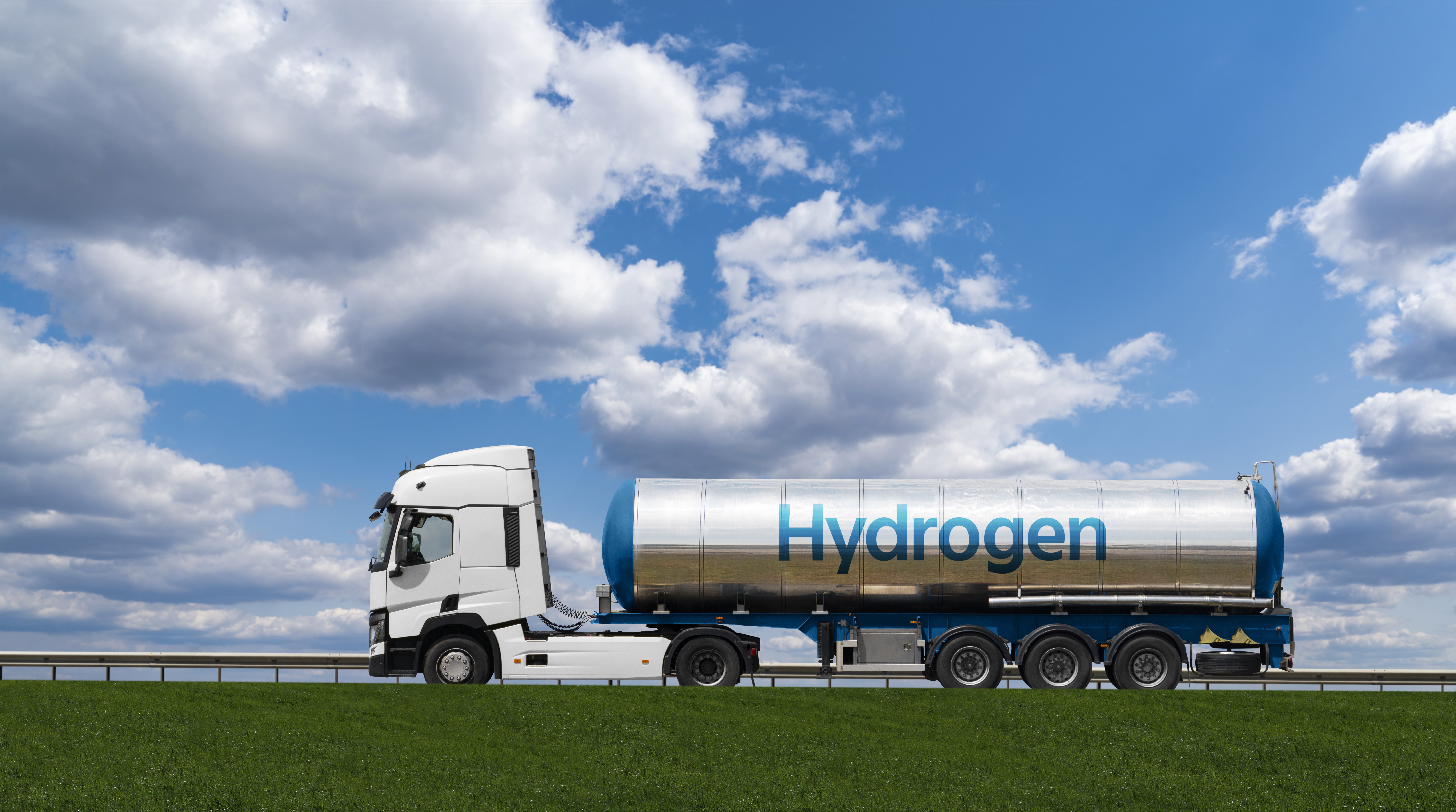 Hydrogen fuel tanker truck on highway under blue sky and clouds