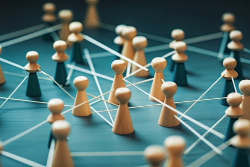 Figuras de madera conectadas por líneas blancas, representando una red o conexión.