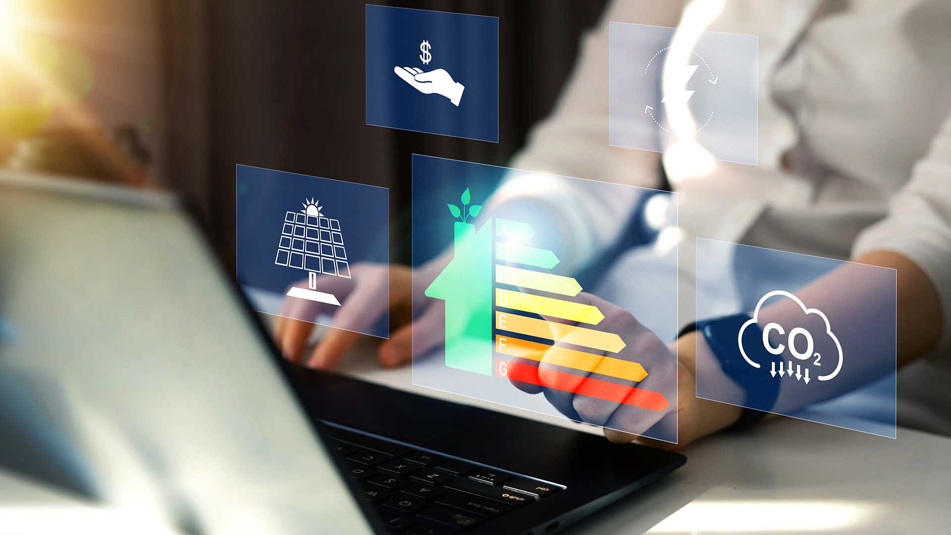 Personer arbetar vid en laptop med överlagrade ikoner för solenergi, energieffektivitet och koldioxidutsläpp, koncept för hållbar energi och miljö in en energideklaration..