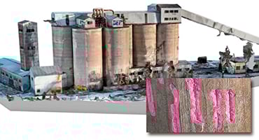 Modell av en industribyggnad med silotorn, omgiven av olika strukturer och detaljer. En närbild visar rosa markeringar.