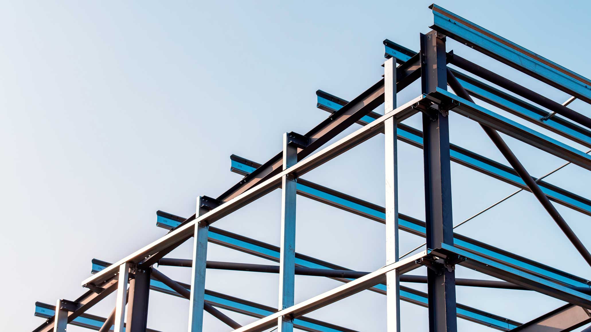 Stålkonstruktion med balkar mot klar himmel.