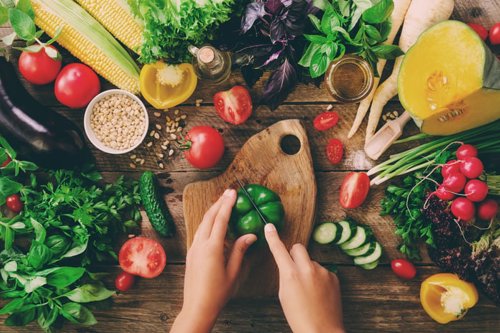 Top down view of two hands chopping up Kiwa certified vegetables