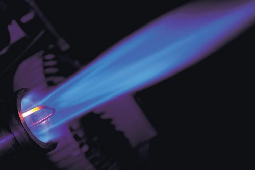 Blue gas flame from a torch burner with a dark background