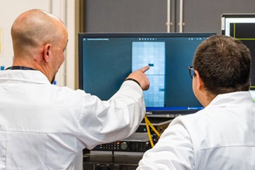 Two kiwa employees analyze PVEL's data on a laptop