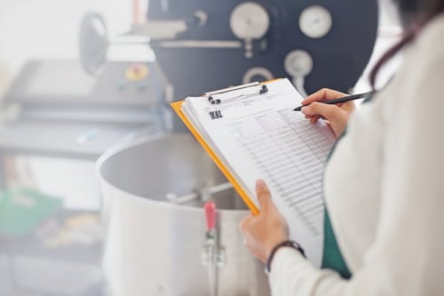 Technician working on a report in a food lab as a part of Kiwa consulting