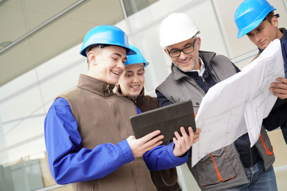 Workers are looking at a report on a food safety training as ones provided by Kiwa.